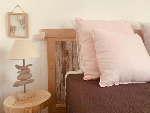 a bedroom with a bed with a lamp and pillows at APPARTEMENT LES COLLINES in Calvi