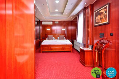 a bedroom with a bed and a red carpet at Prezident Hotel in Novi Sad