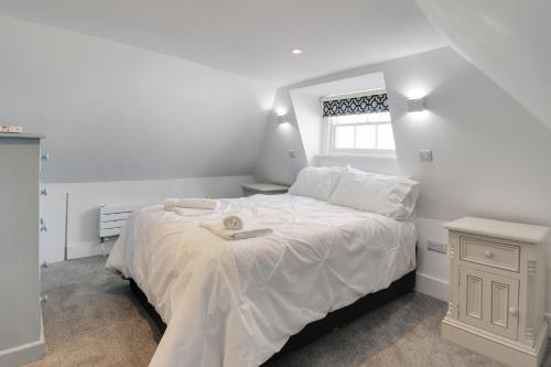 a bedroom with a large white bed with a window at Master accommodation suite 4 attic room in Hastings