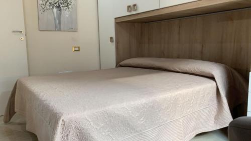 łóżko z drewnianym zagłówkiem w sypialni w obiekcie VILLETTA SANTA LUCIA w mieście Marina di Campo