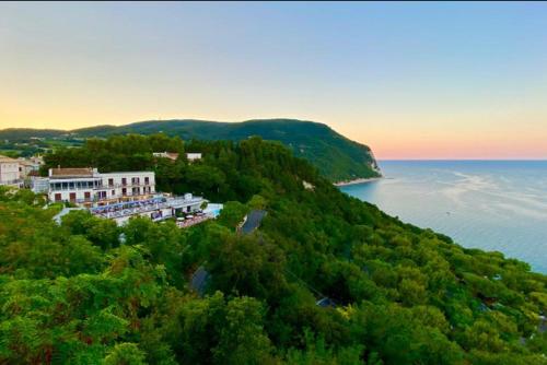 a building on a hill next to a body of water at Camera Vista Mare Sunrise-Top Panorama in Sirolo in Sirolo