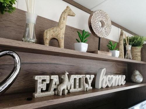 a shelf with a giraffe and a happy home sign at Dreams Luxury Residence in Tattershall