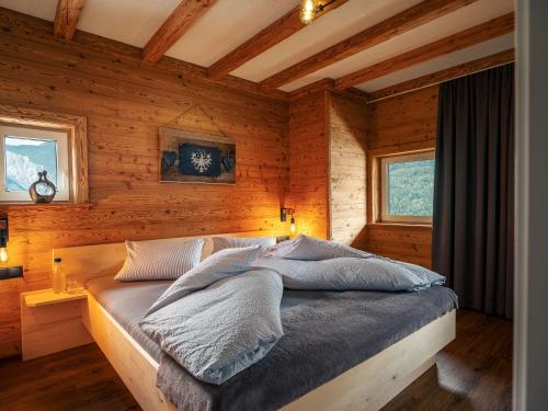 a bedroom with wooden walls and a bed in a room at Schneggnheisl Panoramaappartements in Sautens