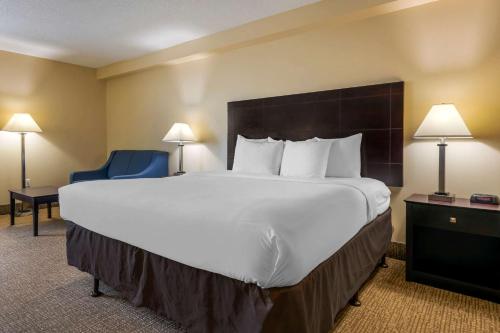 um quarto de hotel com uma cama grande e uma cadeira azul em Comfort Inn International Drive em Orlando
