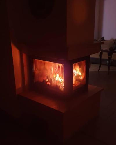 a brick fireplace in a dark room with flames at Edit Villa in Matrafured