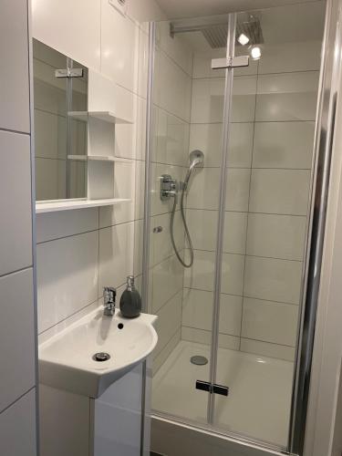 uma casa de banho com um chuveiro e um lavatório. em Prime Host Sophie Apartments em Karlsruhe