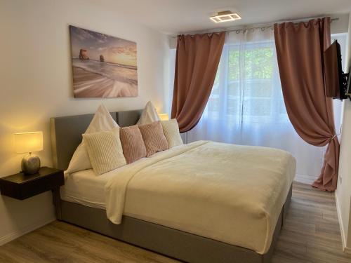 a bedroom with a large bed with pink curtains at Prime Host Sophie Apartments in Karlsruhe