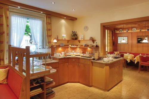 a kitchen with wooden cabinets and a large window at Hotel Kriemhild am Hirschgarten in Munich