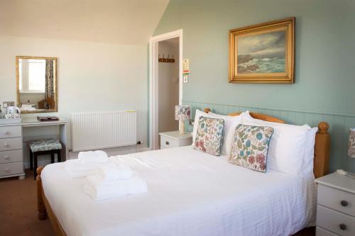 a bedroom with a white bed and white walls at The Royal Oak Hotel in Cullen