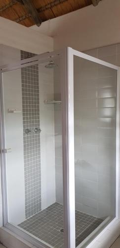 a glass shower door in a bathroom at Pomegranate Selfcatering apartment in Nelspruit