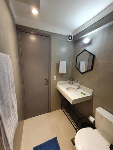 a bathroom with a sink and a toilet and a mirror at Estúdio Centro SP: 25 de Março, Brás, Sta Ifigênia in São Paulo