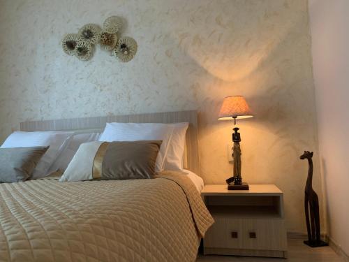 a bedroom with a bed and a lamp on a table at Maya Apartment in Cluj-Napoca
