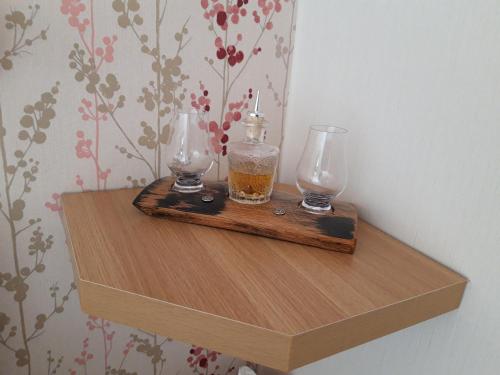 a wooden shelf with two glasses on top of it at Gowanbrae Bed and Breakfast in Dufftown