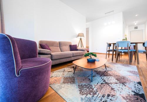 a living room with a purple couch and a table at Apartments Garden Azure Budva in Budva