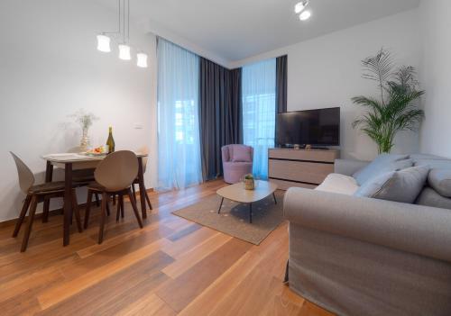 a living room with a couch and a table at Apartments Garden Azure Budva in Budva