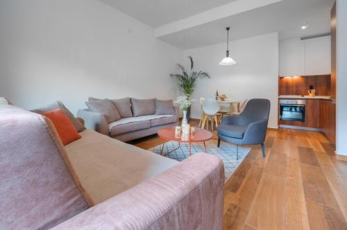a living room with a couch and a table and a kitchen at Apartments Garden Azure Budva in Budva