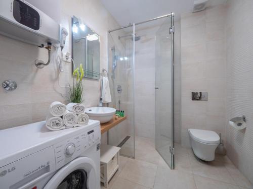 a bathroom with a washing machine and a shower at Apartments Garden Azure Budva in Budva