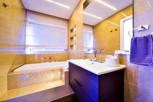 a bathroom with a tub and a sink and a bath tub at Aurora & Tramonto in Zadar