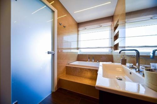 a bathroom with a large tub and a sink at Aurora & Tramonto in Zadar