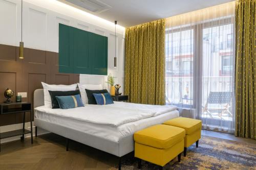 a bedroom with a large bed with yellow accents at Borghese apartment Grand Caravel Varna in Varna City