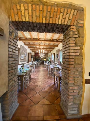 a restaurant with a brick wall and tables and chairs at Agriturismo Rio Coverino in Borghetto