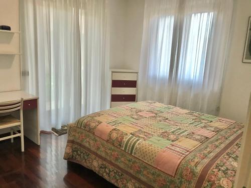 een slaapkamer met een bed, een bureau en gordijnen bij Villetta bifamiliare a 400m dal mare in Cupra Marittima