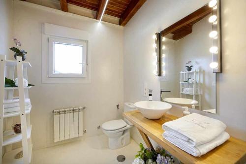 a white bathroom with a sink and a toilet at La Palomba Nature in Cudillero