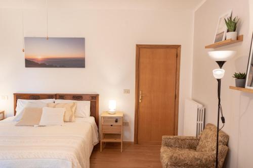 a bedroom with a bed and a chair at B&B Cantico Delle Creature in Assisi