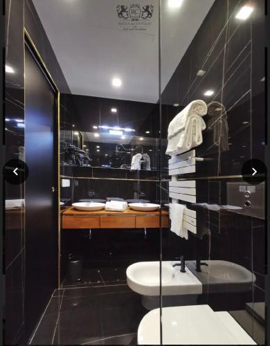 a bathroom with a toilet and a sink and a mirror at B&B Rocca del Civitillo in Notaresco