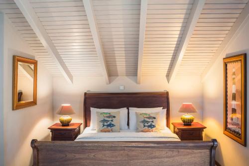 a bedroom with a bed with two lamps on tables at Faros Suites (Adults Only) in Fiskardho