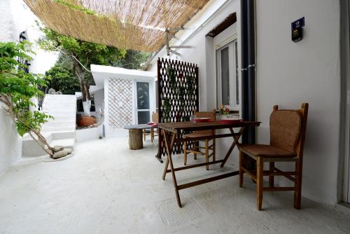 a patio with a wooden table and chairs at Traditional Cretan Country House (9klm from Elafonissi) in Plokamianá