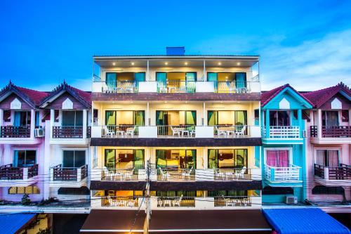 an apartment building with tables and chairs on the balcony at Dream Boutique Hotel in Cha Am