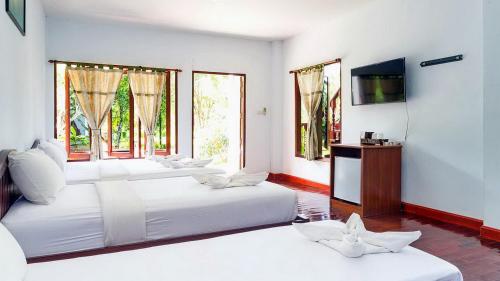 a room with three beds and a tv and windows at Doo Dee Boutique Resort by Swiss Chalet in Ao Nang Beach