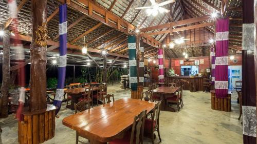 a restaurant with wooden tables and chairs in a room at Doo Dee Boutique Resort by Swiss Chalet in Ao Nang Beach