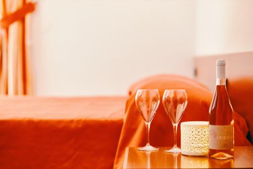 a bottle of wine and two wine glasses on a table at Hotel Almas in Capaccio-Paestum