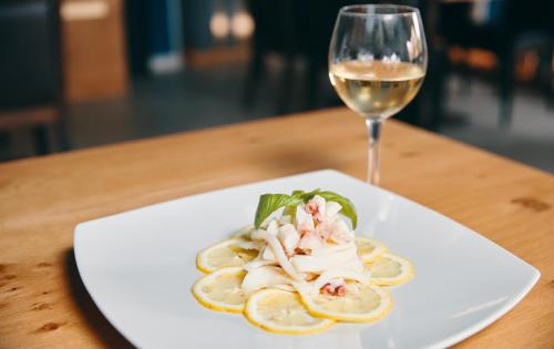 a plate of food and a glass of wine at Hotel Almas in Capaccio-Paestum