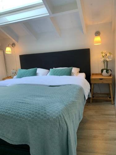 a bedroom with a large bed with a green blanket at Beach House Zandvoort in Zandvoort