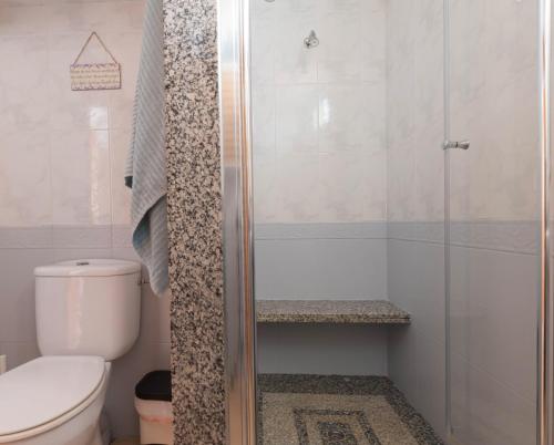 a bathroom with a toilet and a glass shower at Villa Julia in Riumar