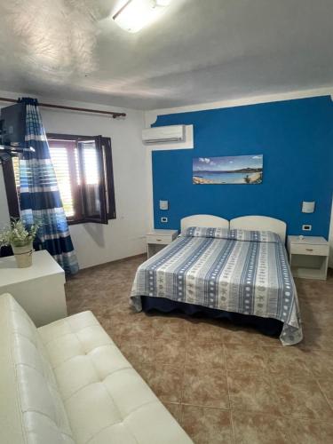 a bedroom with a bed and a blue wall at Il veliero blu camere sul porto in Lampedusa