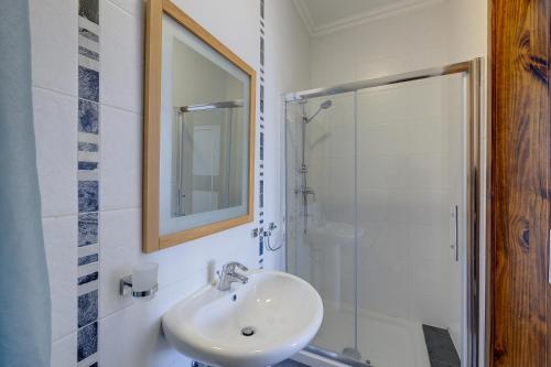 La salle de bains blanche est pourvue d'un lavabo et d'une douche. dans l'établissement Modern 3 Bedroom Apartment in Central Sliema, à Sliema