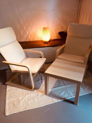 a chair and a table in a room with a lamp at Combrailleurs in Espinasse