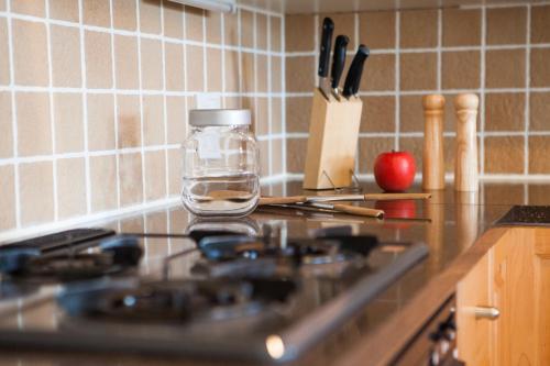 a kitchen counter with a glass jar on top of a stove at Kamakura Apartments in Niseko