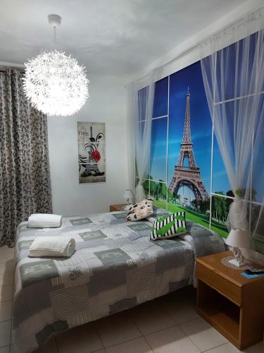 ein Schlafzimmer mit einem großen Fenster mit Blick auf den Eiffelturm in der Unterkunft Domus Pacis Santa Chiara casa per ferie in Loreto