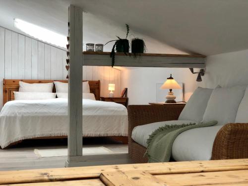 a bedroom with a bed and a table with a couch at BrexHäuschen - Urlaub im Grünen in Höhr-Grenzhausen