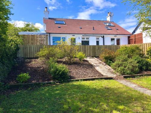 a house with a fence and a yard at Coolfinn Cottage in Ballycastle