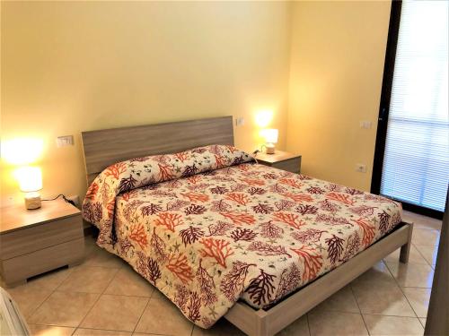 Un dormitorio con una cama y dos mesas y dos lámparas. en La casetta del centro, en Cabras