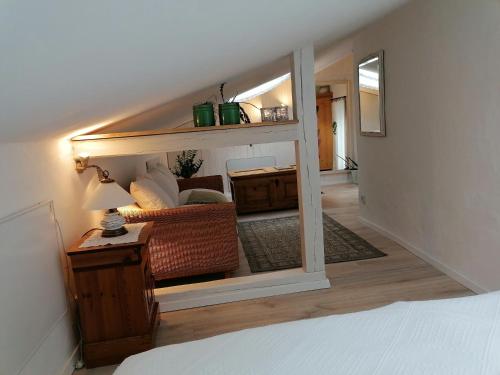 um quarto com uma cama e uma sala de estar com um espelho em BrexHäuschen - Urlaub im Grünen em Höhr-Grenzhausen