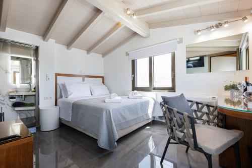 a bedroom with a bed and a table and a chair at Lilian Loft Sea View - Adults Only in Plakias