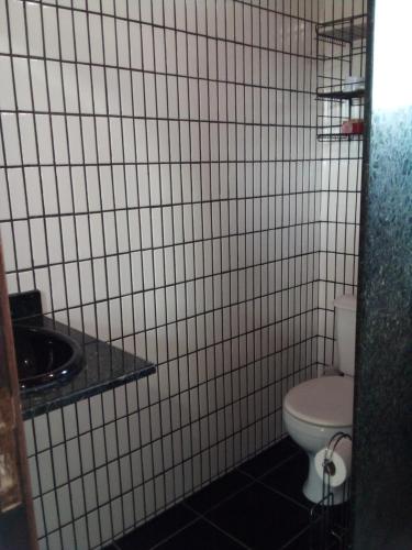 F2xs Guest house في ساكاريما: حمام من البلاط الأبيض مع مرحاض ومغسلة