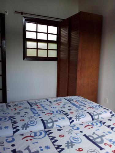 um quarto com uma cama com um cobertor em F2xs Guest house em Saquarema